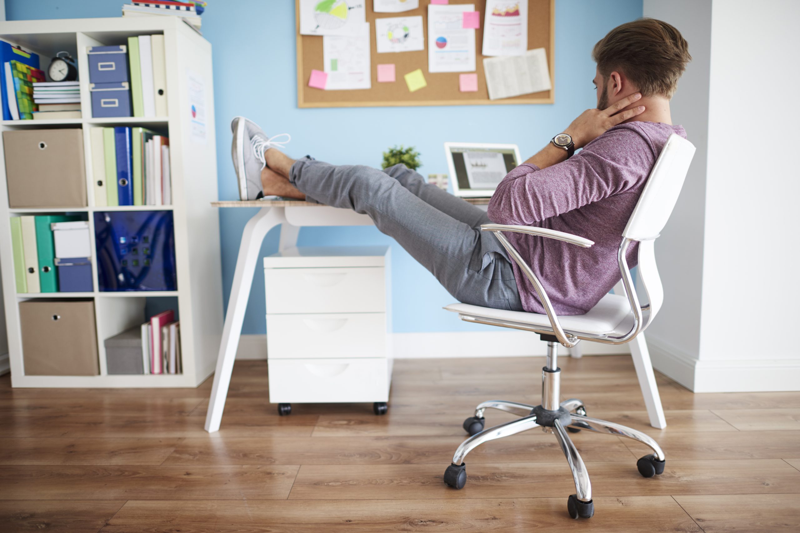 krzesło ergonomiczne w biurze, dopasowane do indywidualnych potrzeb użytkownika, zwiększa komfort pracy, mężczyzna odpoczywa w pracy