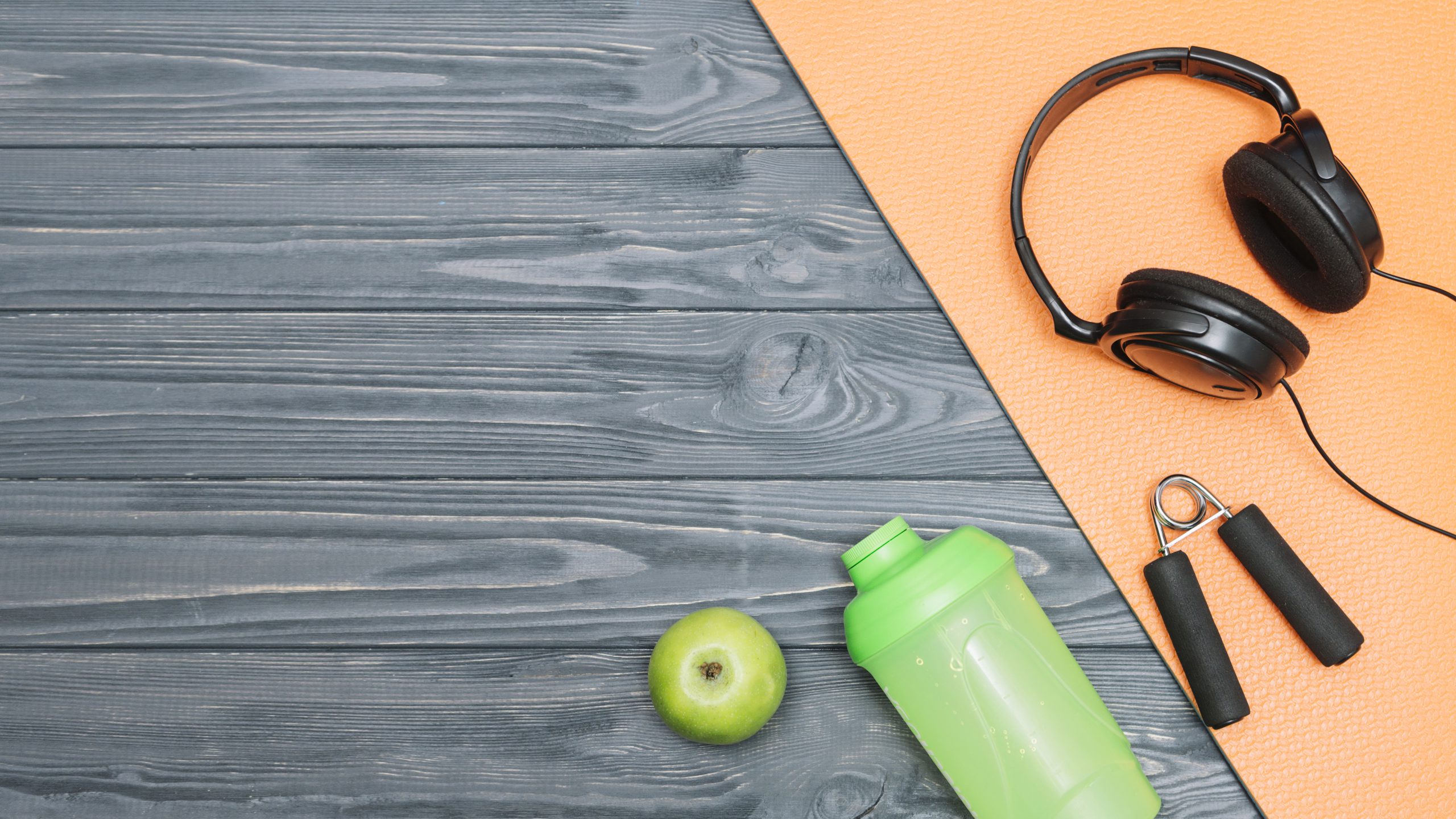 shaker z suplementami diety na siłownię, słuchawki i świeży owoc na podłodze, przygotowanie do treningu