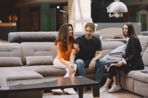 Para siedzi na komplecie wypoczynkowym w salonie meblowym.