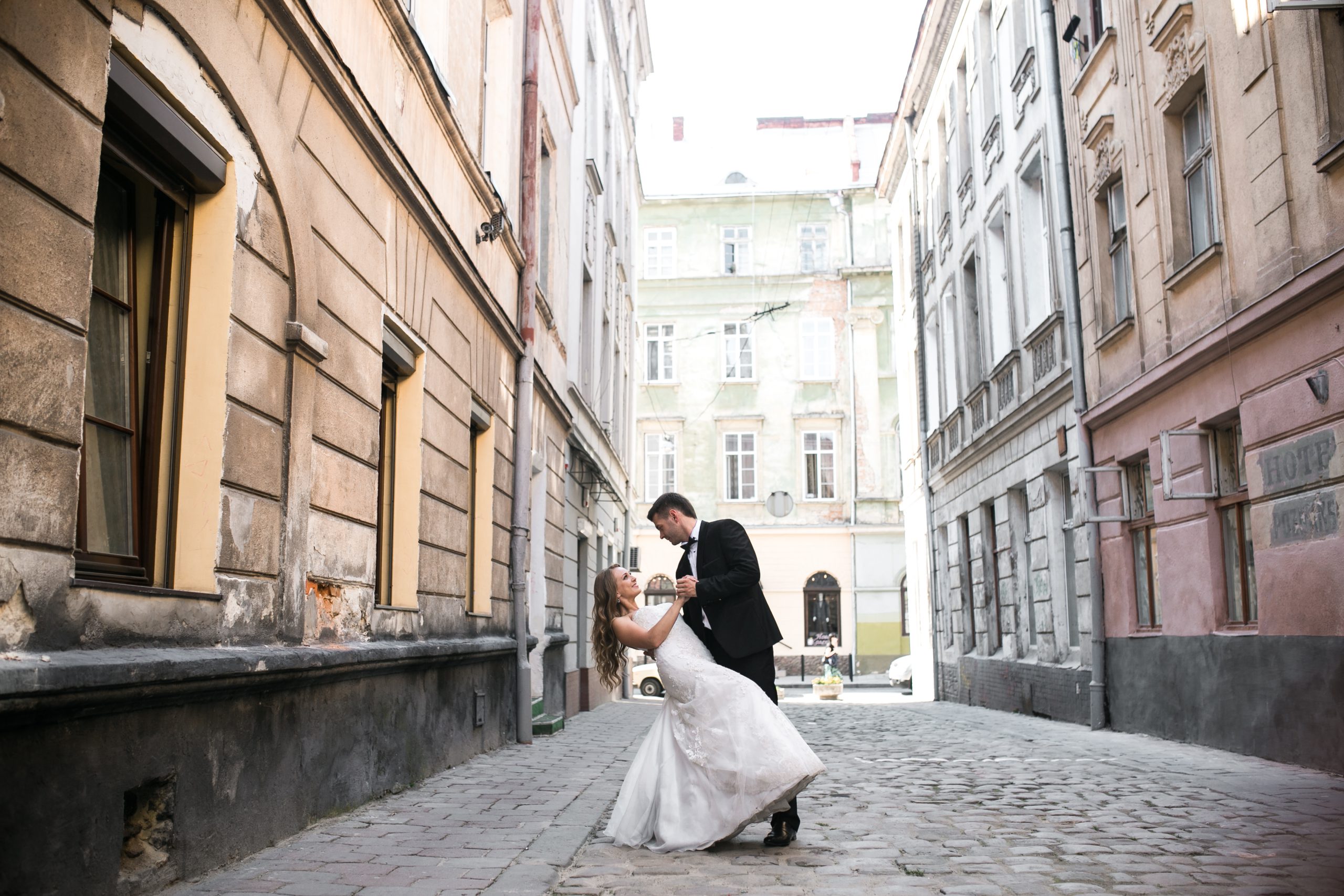wesele w krakowie- młoda para na krakowskiej ulicy między kamienicami