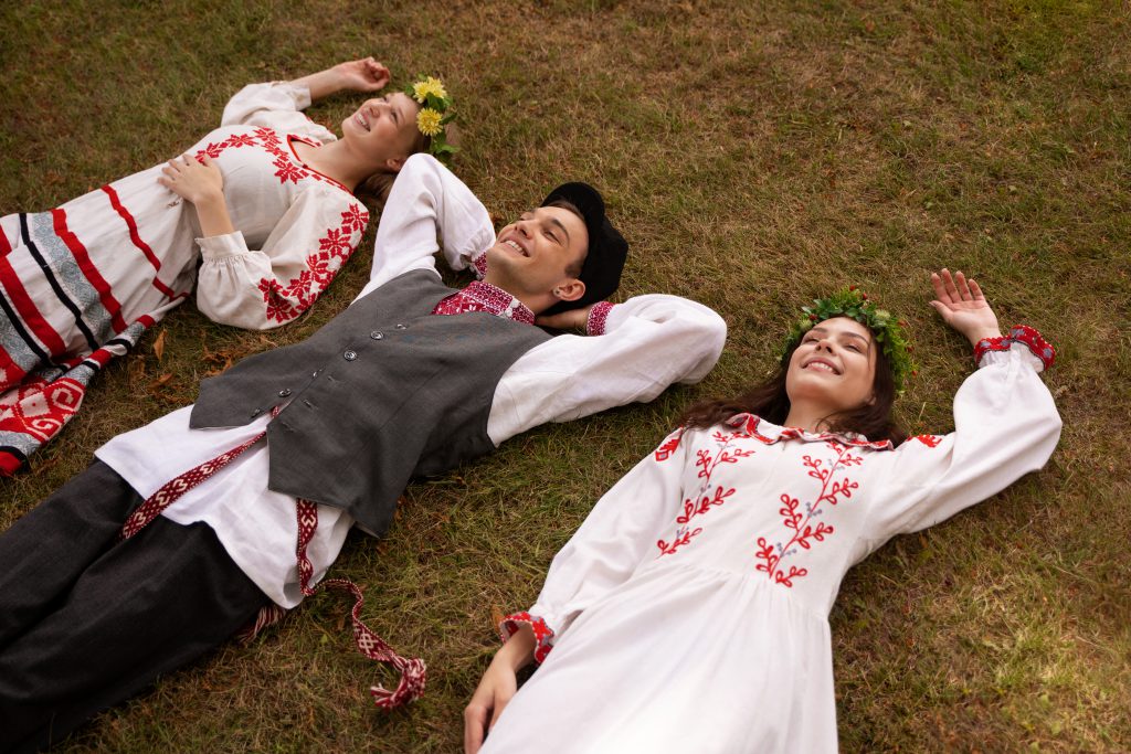 ludzie ubrani w stroje ludowe leżą na ziemi - torebka góralska 