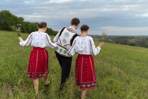 osoby idące przez łąke w strojach góralskich - spodnie góralskie męskie