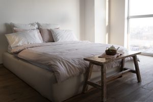 łóżko z jasnym posłaniem w sypialni - łóżko dla dorosłych