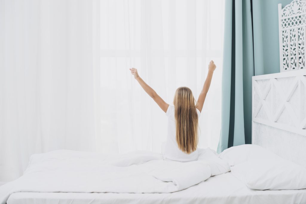 dziewczyna rozciągająca się na łóżku - łóżko do sypialni z materacem
