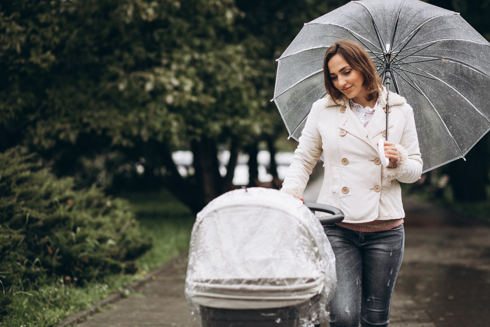 matka na spacerze z dzieckiem w wózku podczas deszczu